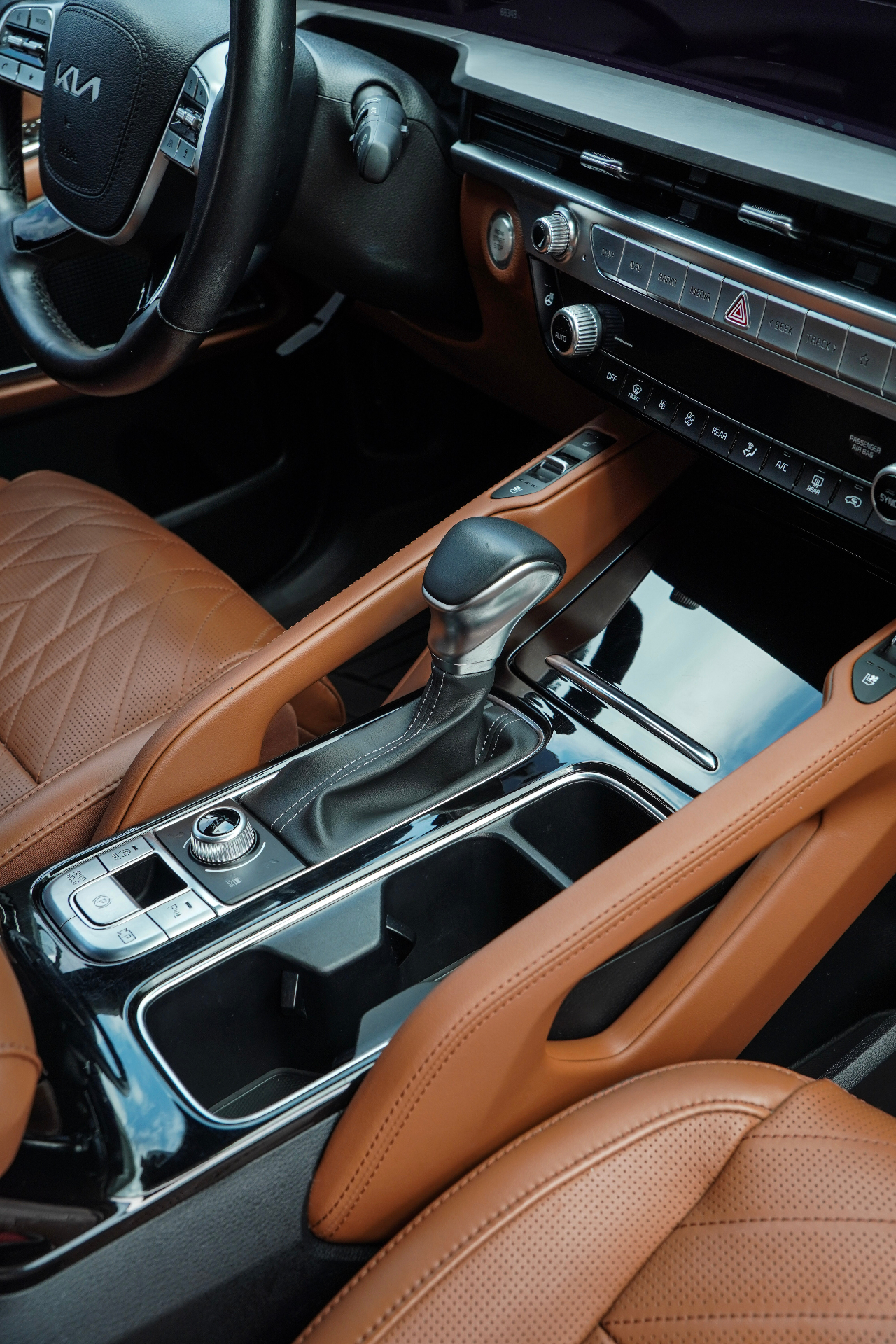 Luxury car interior with tan leather seats and detailed center console